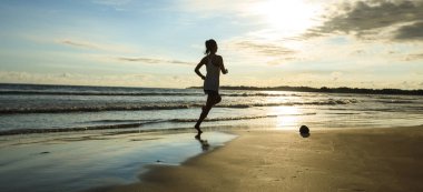 Güneş doğarken plajda koşan fitness kadın koşucusu