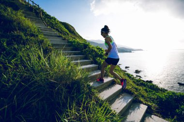 Kararlı kadın ultramaraton koşucusu sahil dağ merdivenlerinde kadar çalışan