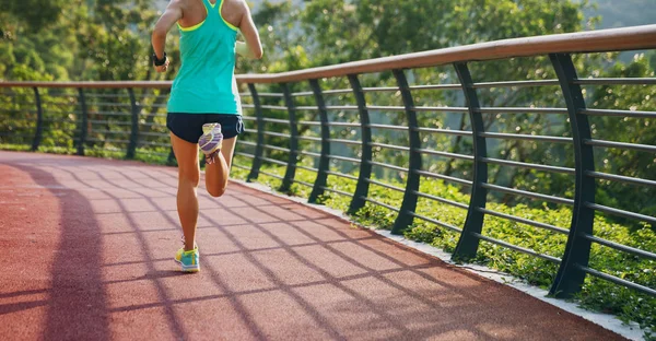 Runner athlete running on spring forest trail. woman fitness jogging workout wellness concept.