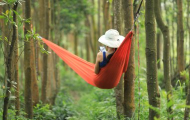 Tropikal yağmur ormanlarında akıllı telefon ile hamakta dinlenen kadın