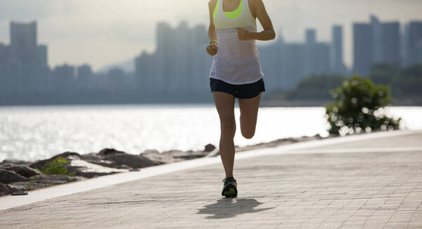 Fitness sportswoman running training for marathon on sunny coast
