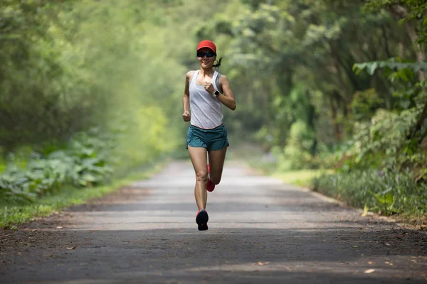 Female runner running at summer park trail . Healthy fitness woman jogging outdoors.