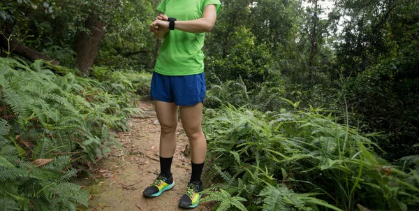 Ultra marathon runner looking smart watch