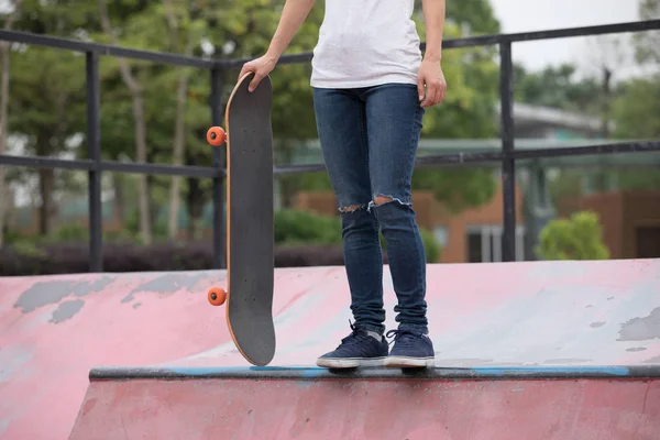 Skateboarder skateboarding on skatepark ramp in city