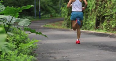 Yazlık park yolunda koşan kadın koşucu. Sağlıklı fitness kadın açık havada koşu, arka görüş