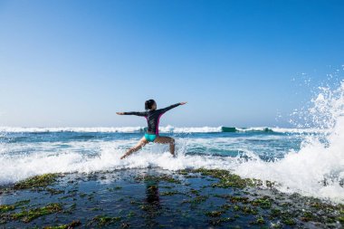 Yaklaşan güçlü deniz dalgaları bakan sahil uçurum kenarında Yoga kadın meditasyon