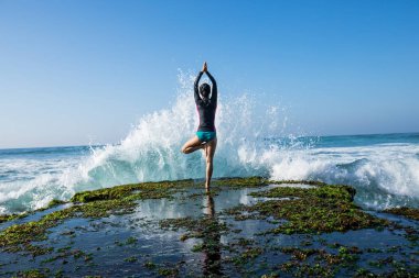 Yaklaşan güçlü deniz dalgaları bakan sahil uçurum kenarında Yoga kadın meditasyon