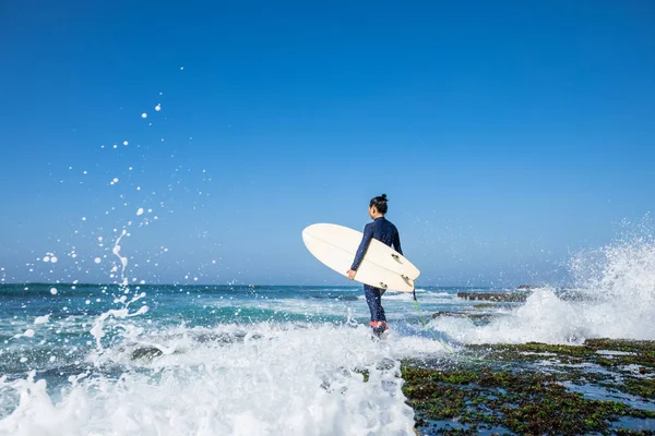 大きな波をサーフィン サーフボードに行くと女性サーファー — ストック写真