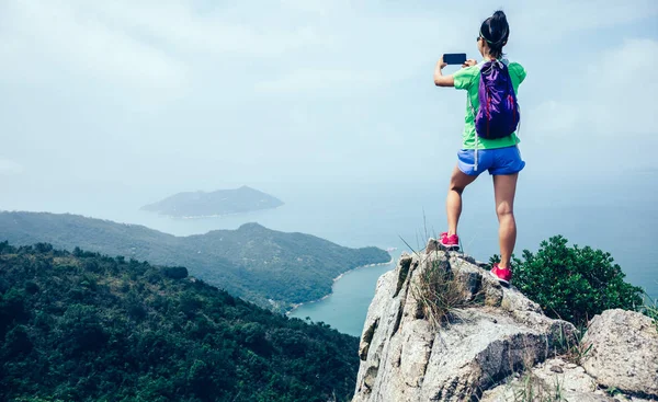 Udane Kobieta Hiker Biorąc Obraz Smartfonem Seaside Mountain Top — Zdjęcie stockowe