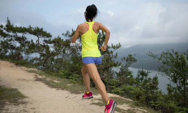 森の山道を走るスポーツウェアトレイルのスポーティな若い女性 香港でジョギングするフィットネスガール — ストック写真