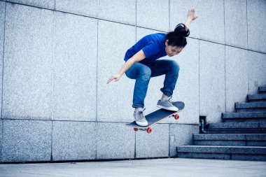 Kadın kaykaycı şehirde ollie yapıyor