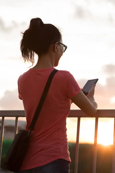 女性は夕日香港でスマートフォンを使用 — ストック写真
