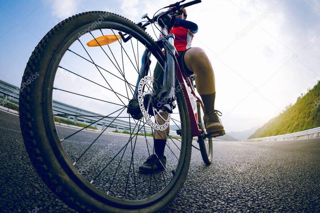 Woman cyclist riding bike on highway