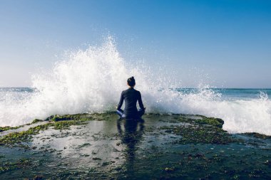 Yaklaşan güçlü deniz dalgaları bakan sahil uçurum kenarında Yoga kadın meditasyon
