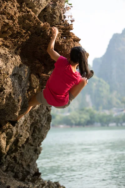 年轻女子攀岩爬在海边岩石山 — 图库照片