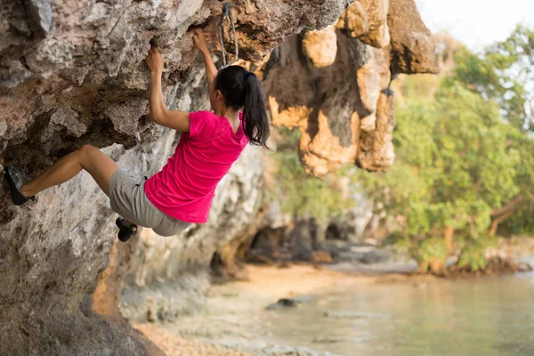 海辺山岩でクライミング若い女性ロック クライマー — ストック写真