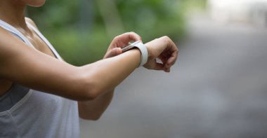 Tropikal yağmur ormanlarında koşmadan önce akıllı hareket ayarlayan kadına yakın çekim.