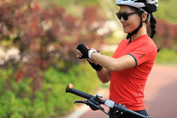 Female Cyclist Looking Smartwatch While Riding Bike — Stockfoto