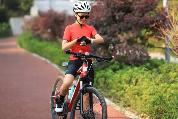 Radfahrerin Schaut Bei Sonnigem Wetter Auf Smartwatch — Stockfoto