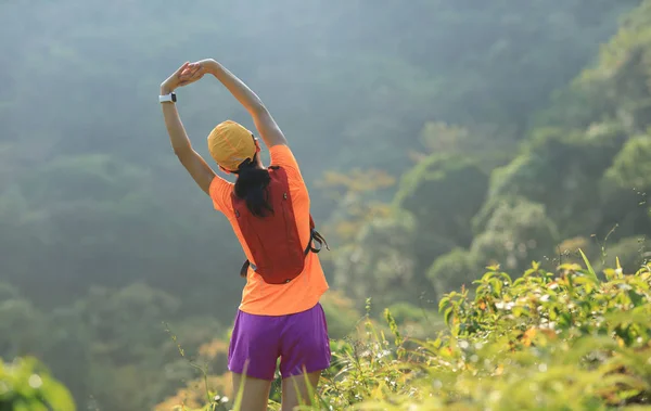 熱帯林歩道を走りながら腕を伸ばす女性ハイカーの後ろ姿 — ストック写真