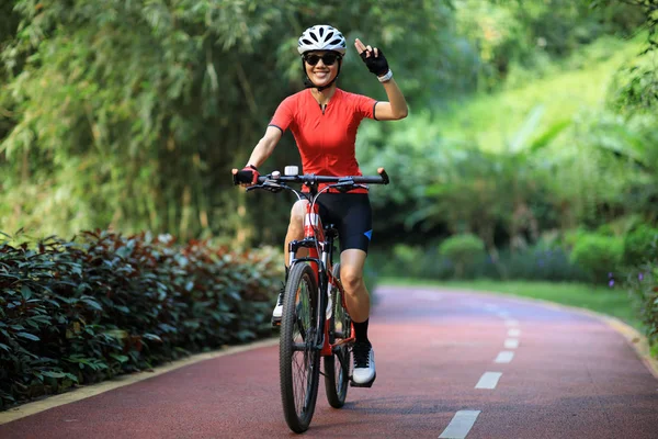Genç Bir Kadın Tropik Park Yolunda Bisiklet Sürerken Selam Veriyor — Stok fotoğraf