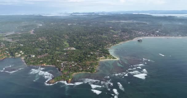 Images aériennes de vagues océaniques lavant le rivage d'un village de pêcheurs au Sri Lanka 