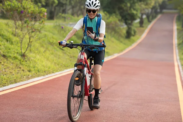 Mujer Montando Carril Bici Del Parque Utilizando Teléfono Inteligente Día — Foto de Stock