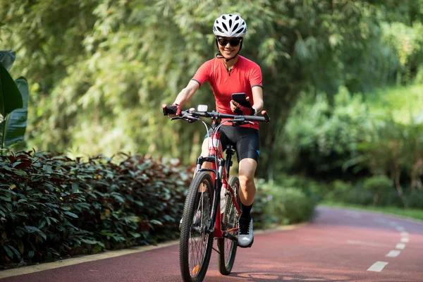 Kız Bisiklet Yolunda Güneşli Havada Bisiklet Sürerken Akıllı Telefon Kullanıyor — Stok fotoğraf