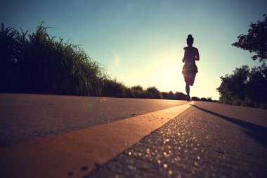 Fitness kadını sabah deniz kenarında koşuyor.