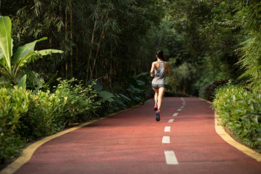 Park yolunda koşan kadın koşucu