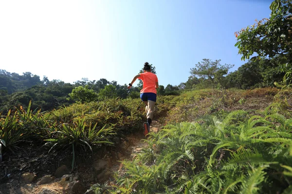 热带森林里跑上山坡的女超级马拉松选手 — 图库照片