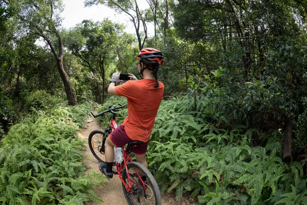 Cyclist Using Smartphone Taking Picture While Riding Bike Rainforest Trail — Stock Photo, Image