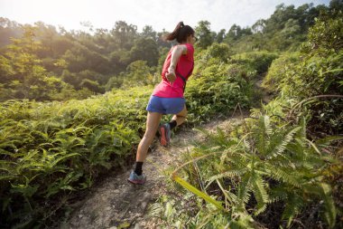 Tropikal ormanda dağ yamacında koşan kadın ultra maratonu