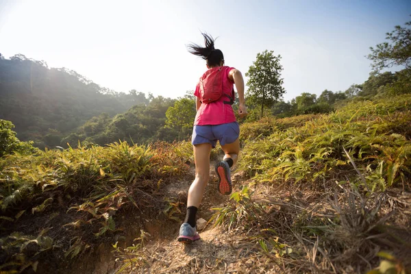 熱帯林の山の斜面を駆け上がる女トレイルランナー — ストック写真