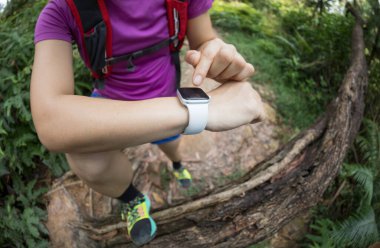 Asyalı kadın ultra-maraton koşucusu tropikal yağmur ormanlarında koşmadan önce akıllı seti kurdu.