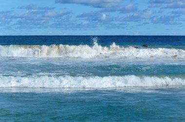 Mavi gökyüzünün altında güzel, güçlü deniz dalgaları 