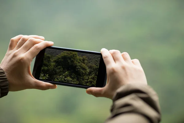 春の携帯電話で写真を撮るハイカーの手自然 — ストック写真