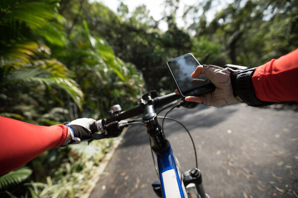Используйте приложение смартфона для навигации во время езды на велосипеде по лесной тропе
