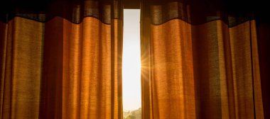 Güneş ışığı ışınları odayı keyiflendiriyor açık perde aralığında