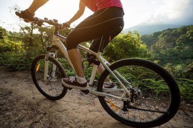 Kadın bisikletçi dağlarda bisiklet sürüyor. 