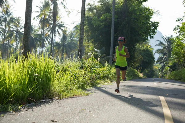 年轻健康的女子在热带森林小径上奔跑 — 图库照片