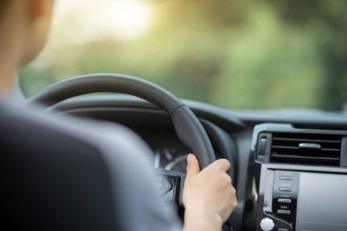 İnsanlar şehir yolunda araba sürerken direksiyon başında el ele tutuşuyorlar.