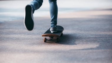 Kaykaycı bacakları otoparkta kaykay yapıyor.