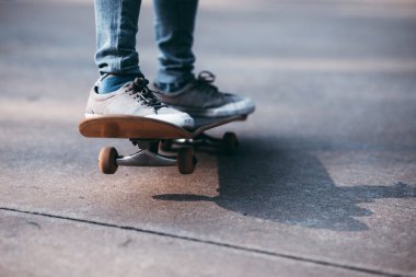 Kaykaycı bacakları otoparkta kaykay yapıyor.