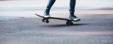 Kaykaycı bacakları otoparkta kaykay yapıyor.