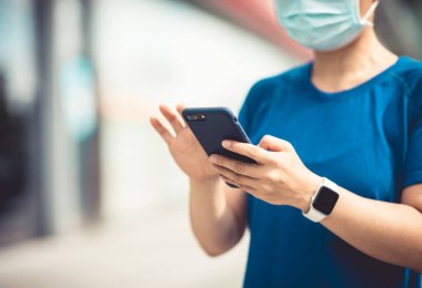 Şehirde akıllı telefon kullanan bir kadın