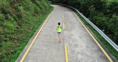 Dağ yolunda koşan fitness kadın koşucusunun hava manzarası