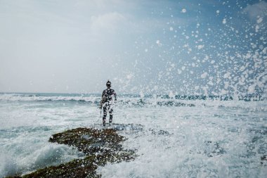 Sörf tahtası olan bir kadın deniz kenarında sörf yapacak.