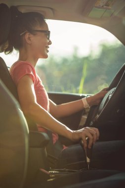 Doğada araba kullanan Asyalı kadın sürücü.