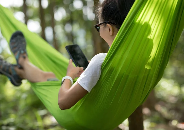 热带雨林用智能手机在吊床上放松 — 图库照片